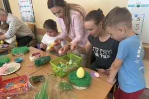 Dzieci z rodzinami tworzą stroiki.