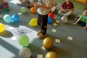 Dzieci biorą udział w zabawie z balonami.