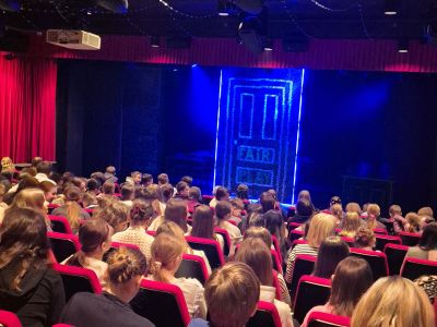 Uczniowie oglądają spektakl w teatrze.