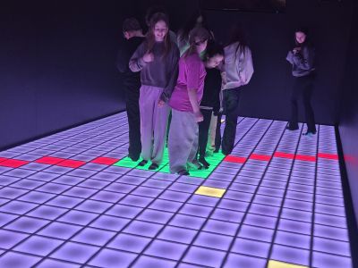 Uczniowie grają w gry na matach interaktywnych.