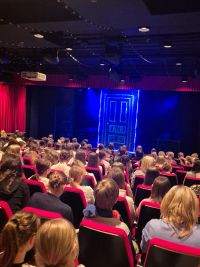 Uczniowie oglądają sztukę teatralną w teatrze.