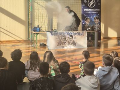 Prowadzący pokazuje doświadczenie z parą wodną.