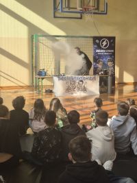 Prowadzący wykonuje doświadczenie podczas pokazów naukowych.