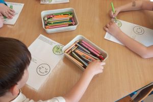 Dzieci kolorują przy stoliczkach.