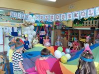 Dzieci bawią się chustą z balonami.