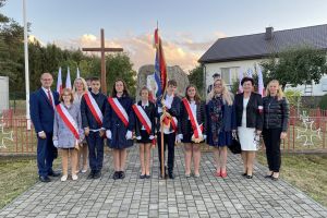 Uczniowie trzymają sztandar na uroczystości rocznicy bitwy